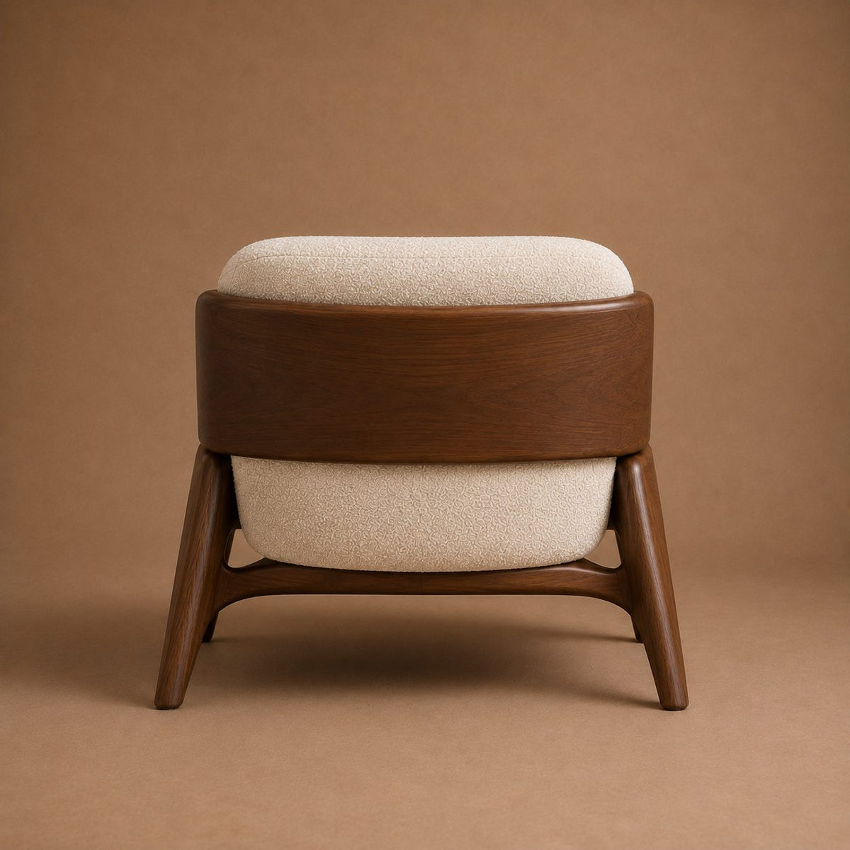 Nefer armchair from directly behind, showing the curved back panel and sculpted stretcher